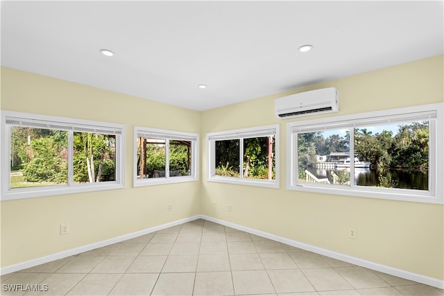 unfurnished sunroom with a wealth of natural light, a water view, and a wall mounted AC