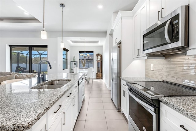 kitchen featuring white cabinets, light stone counters, sink, and appliances with stainless steel finishes