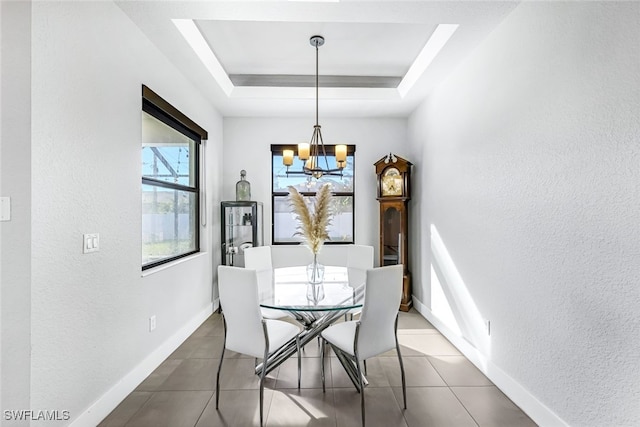 tiled dining room featuring a raised ceiling, plenty of natural light, and a notable chandelier