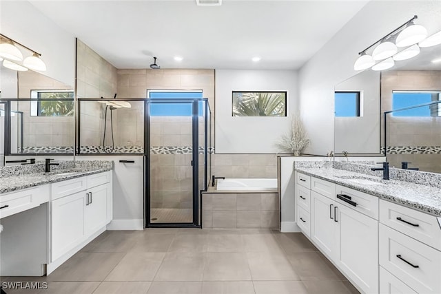 bathroom featuring tile patterned flooring, vanity, and shower with separate bathtub