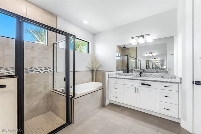 bathroom featuring tile patterned floors, vanity, and shower with separate bathtub