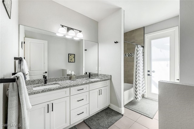 bathroom featuring tile patterned flooring, vanity, and shower / bath combo with shower curtain