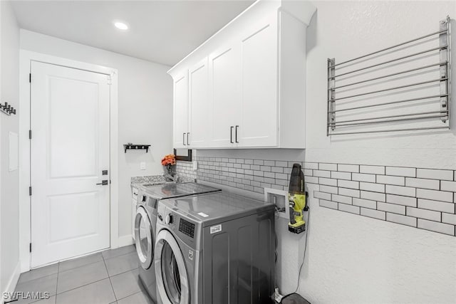 washroom with light tile patterned flooring, cabinets, independent washer and dryer, and sink