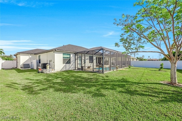 back of house with a lawn, a lanai, a fenced in pool, and central air condition unit