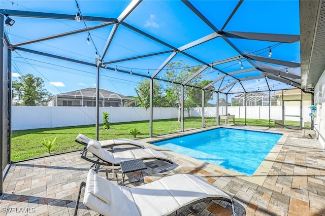 view of pool with a patio area, a lanai, and a lawn