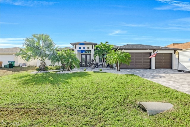 view of front facade featuring a front yard, french doors, and a garage