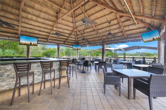 view of patio with a gazebo, ceiling fan, and an outdoor bar