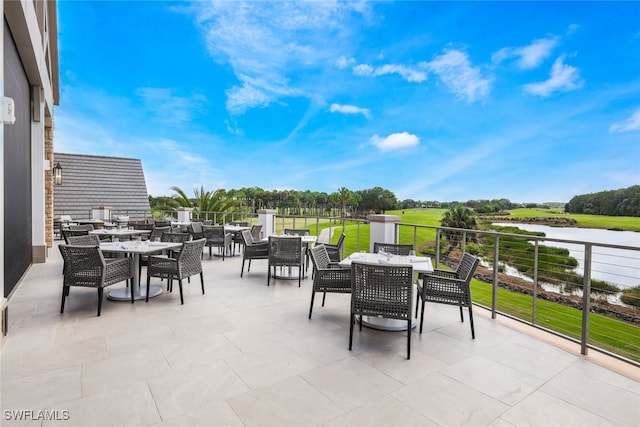 view of patio with a balcony and a water view