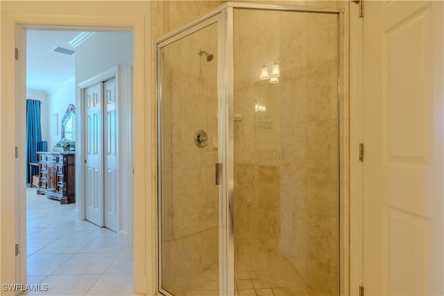 bathroom featuring a shower with door, tile patterned flooring, and ornamental molding