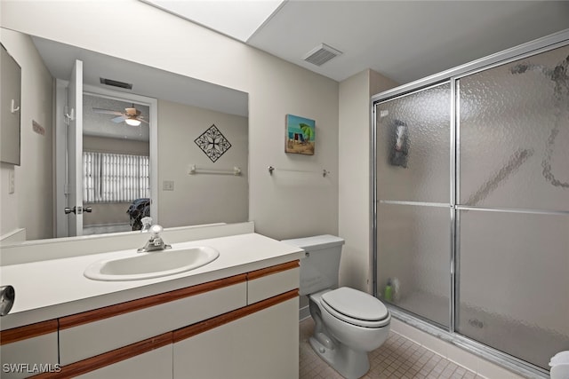 bathroom featuring toilet, an enclosed shower, vanity, and tile patterned flooring