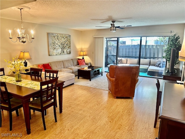 dining area featuring a textured ceiling, light hardwood / wood-style floors, and ceiling fan with notable chandelier