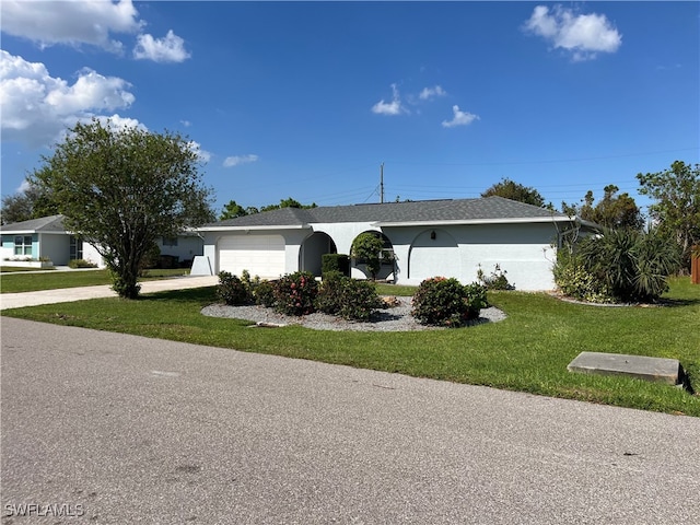 single story home with a garage and a front lawn