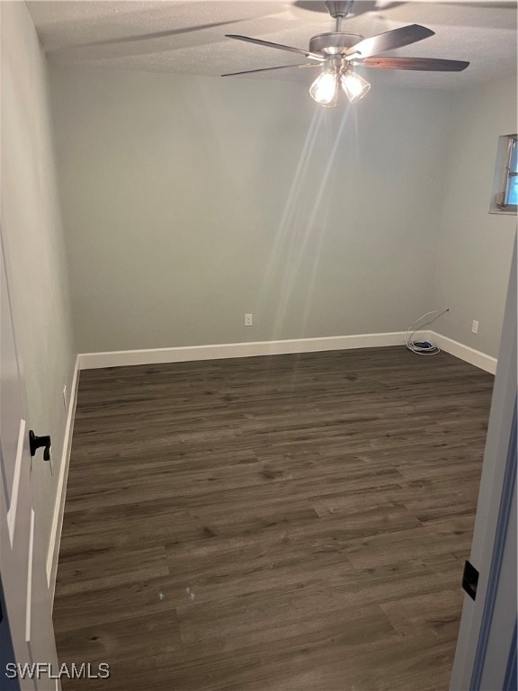 empty room featuring ceiling fan, dark hardwood / wood-style flooring, and a textured ceiling