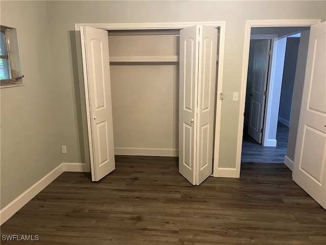 unfurnished bedroom featuring dark hardwood / wood-style floors and a closet