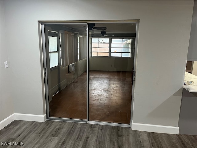 empty room with a wall mounted air conditioner and dark hardwood / wood-style flooring