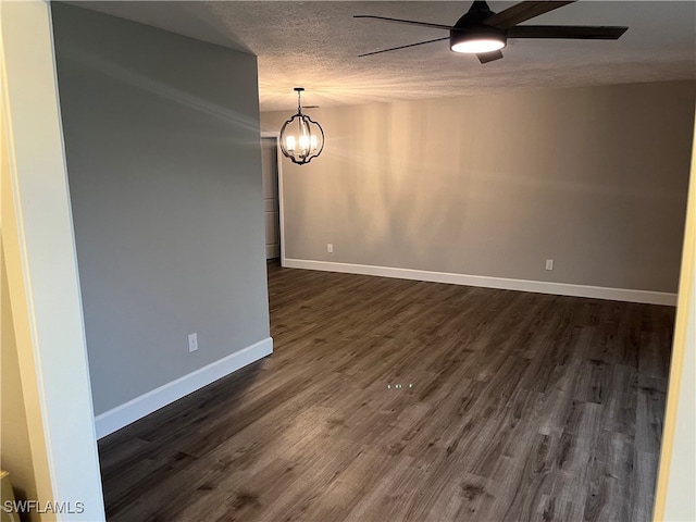 spare room with dark hardwood / wood-style flooring, ceiling fan with notable chandelier, and a textured ceiling