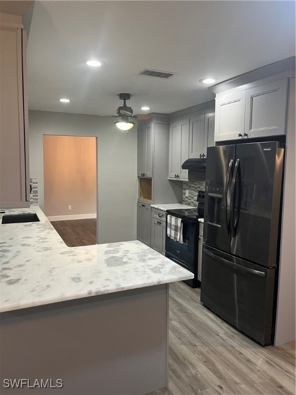 kitchen with gray cabinetry, stainless steel fridge with ice dispenser, light hardwood / wood-style flooring, and black electric range