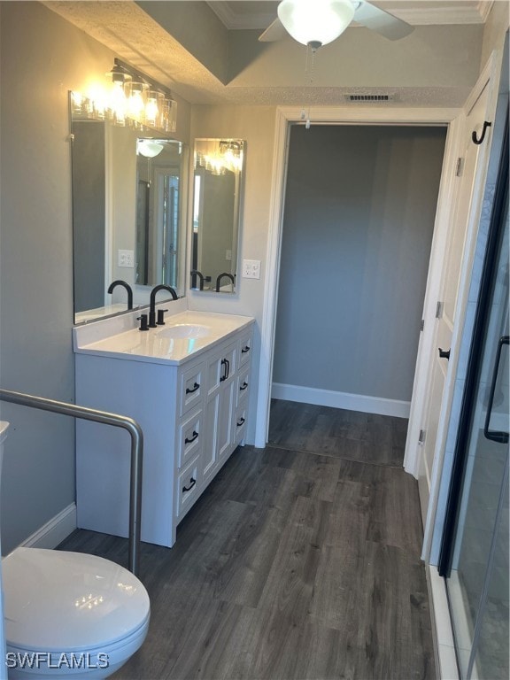 bathroom with hardwood / wood-style flooring, vanity, ceiling fan, and ornamental molding