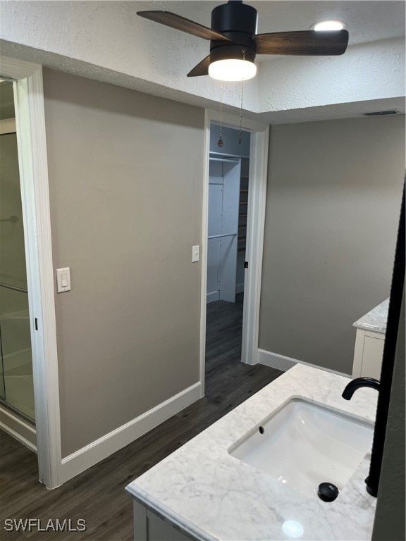 bathroom with ceiling fan, a shower with door, vanity, and wood-type flooring