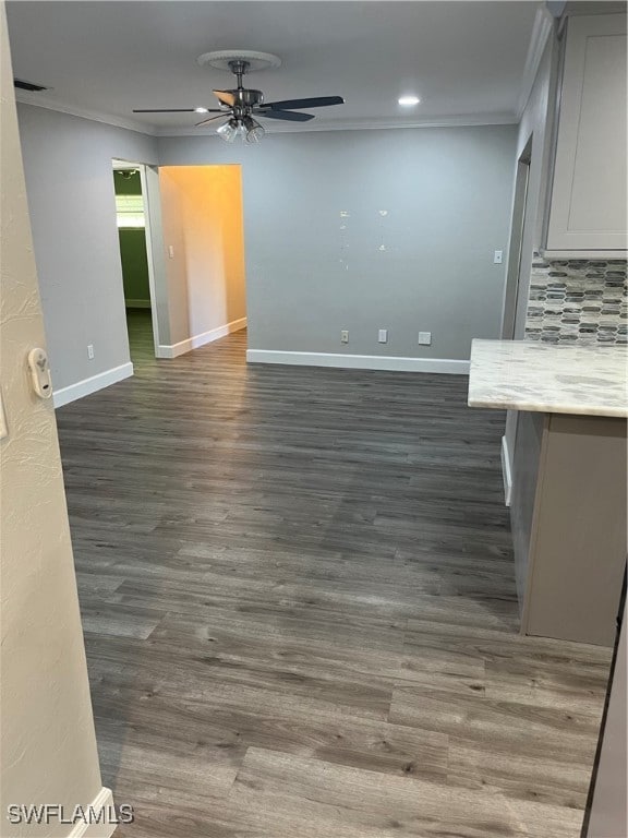 empty room with ceiling fan, dark hardwood / wood-style flooring, and crown molding