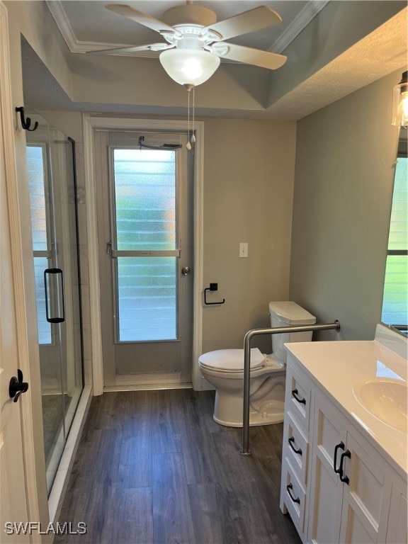 bathroom with an enclosed shower, hardwood / wood-style floors, ceiling fan, and crown molding