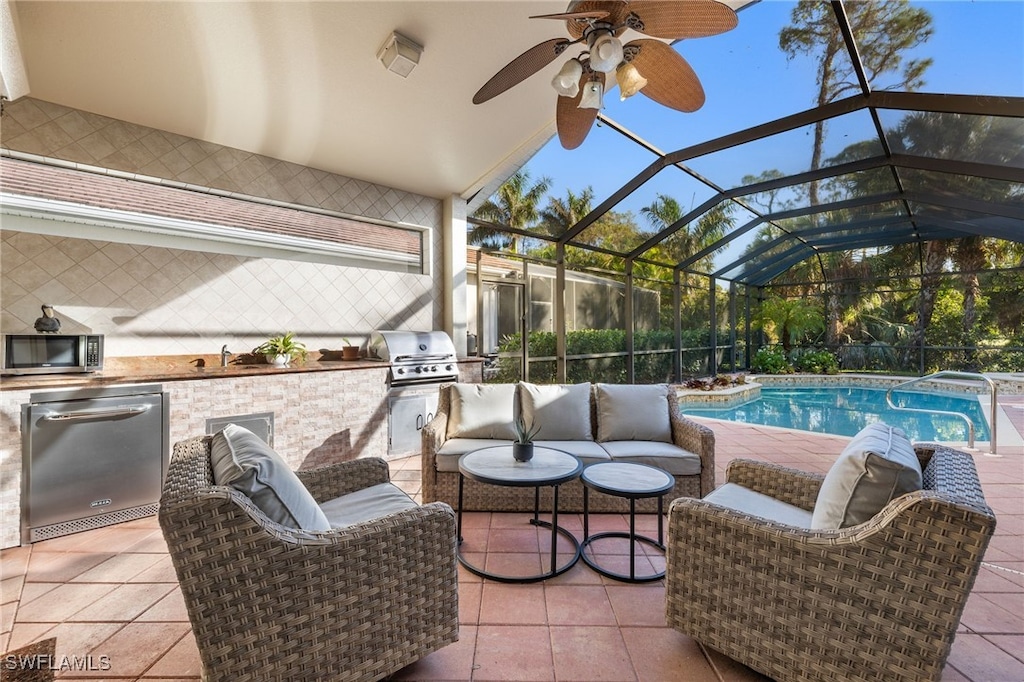 view of patio featuring glass enclosure, area for grilling, and ceiling fan