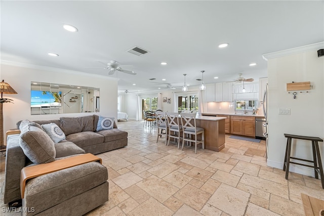 living room featuring ceiling fan, sink, and ornamental molding