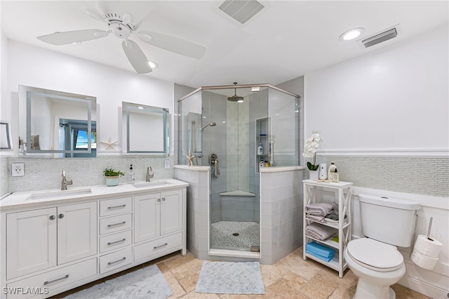 bathroom with backsplash, walk in shower, vanity, ceiling fan, and toilet