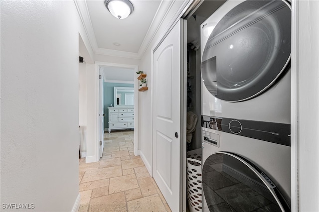 washroom with stacked washer / drying machine and ornamental molding