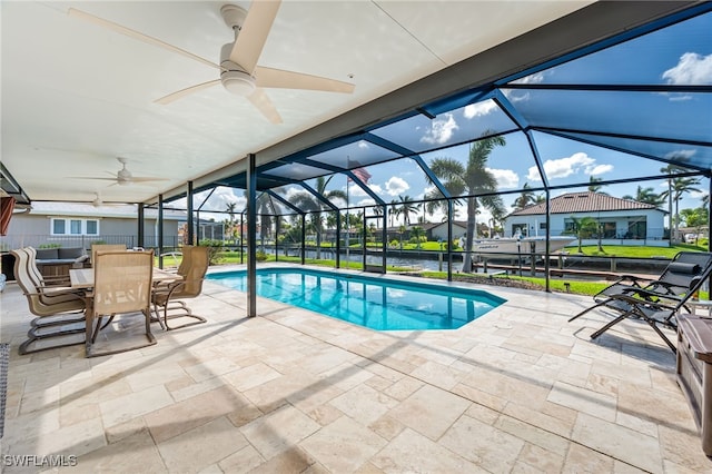 view of swimming pool with ceiling fan, a patio area, and a lanai