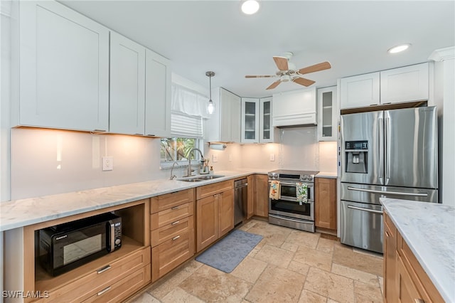 kitchen featuring sink, light stone counters, decorative light fixtures, white cabinets, and appliances with stainless steel finishes