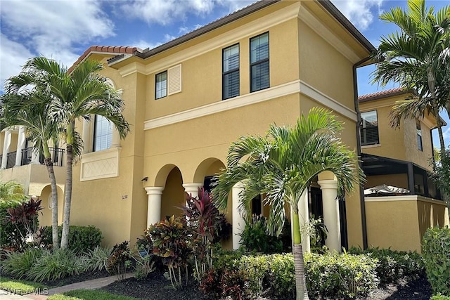 mediterranean / spanish house with a tiled roof and stucco siding