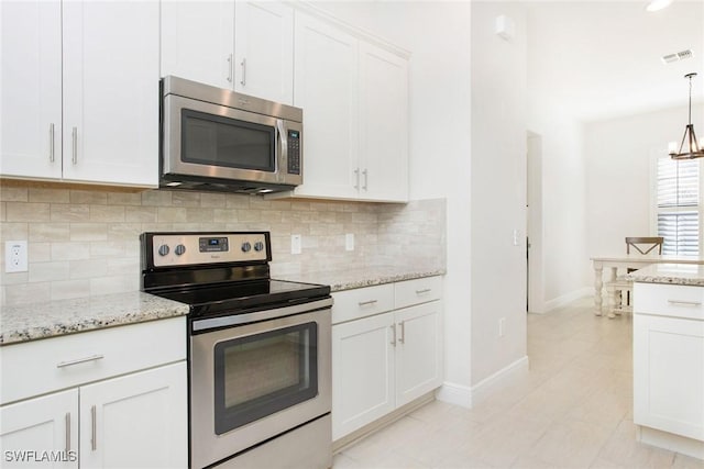 kitchen with visible vents, stainless steel appliances, white cabinetry, pendant lighting, and backsplash