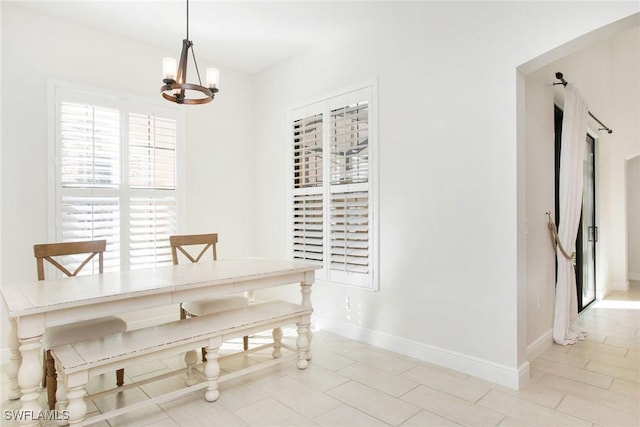 unfurnished dining area with a notable chandelier and baseboards