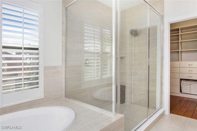 full bath with tile patterned floors, a garden tub, and a shower stall