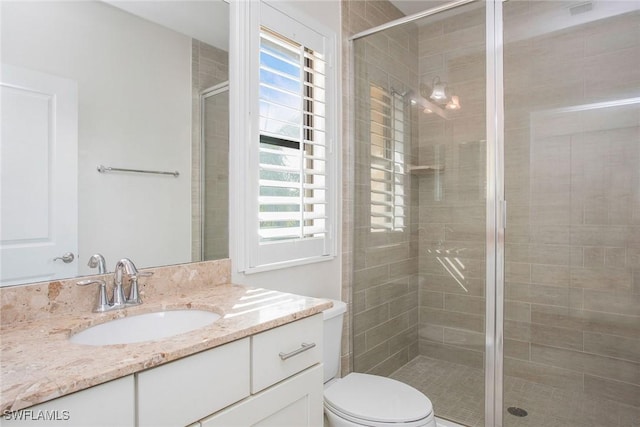 full bathroom with a shower stall, toilet, and vanity