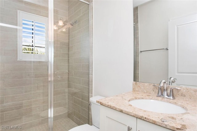 full bath featuring a stall shower, vanity, and toilet