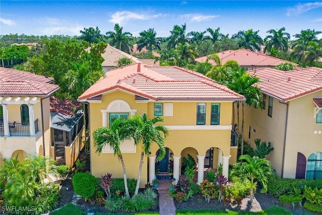 mediterranean / spanish house with stucco siding and a tiled roof