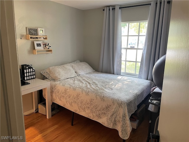 bedroom featuring wood-type flooring and multiple windows