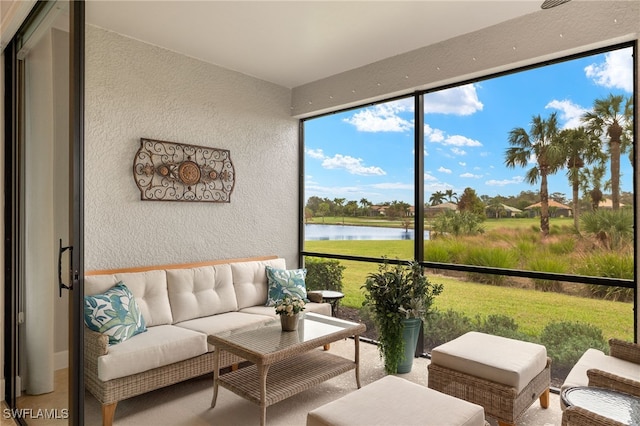 sunroom featuring a water view