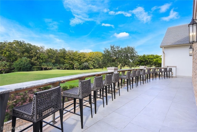 wooden deck with a lawn and a patio