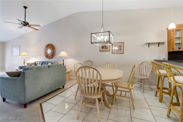 tiled dining area with ceiling fan with notable chandelier and vaulted ceiling