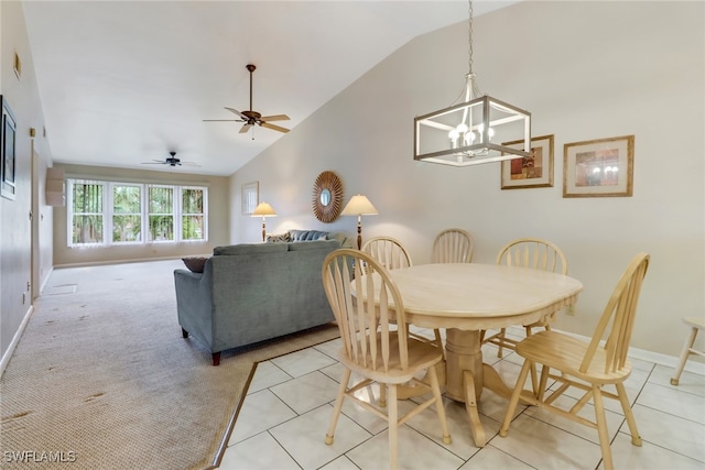 tiled dining room with high vaulted ceiling and ceiling fan with notable chandelier