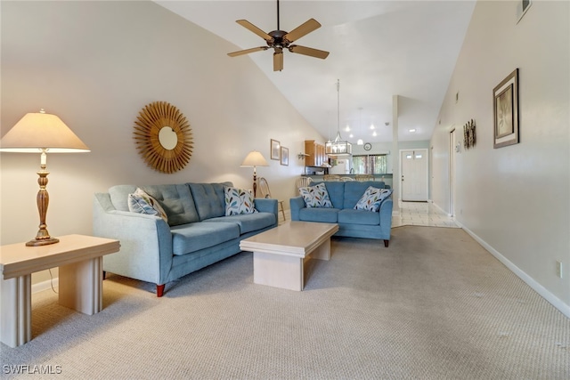 carpeted living room featuring ceiling fan with notable chandelier and high vaulted ceiling