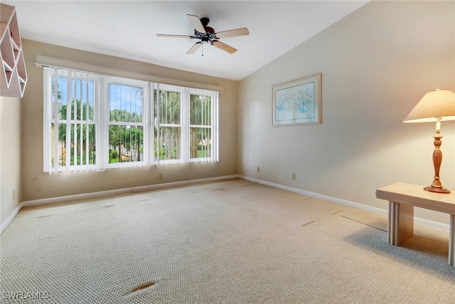 carpeted spare room featuring vaulted ceiling and ceiling fan