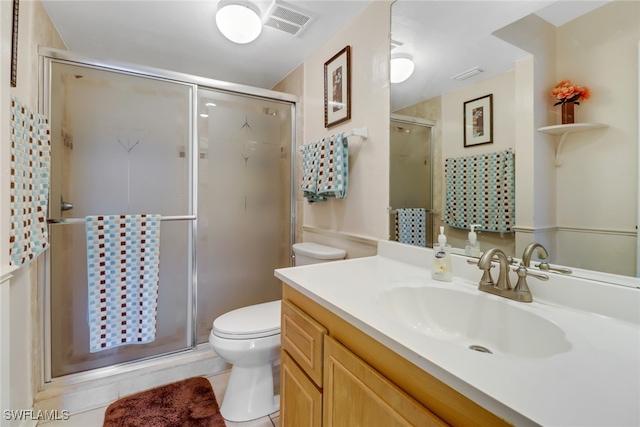 bathroom with toilet, vanity, tile patterned flooring, and walk in shower