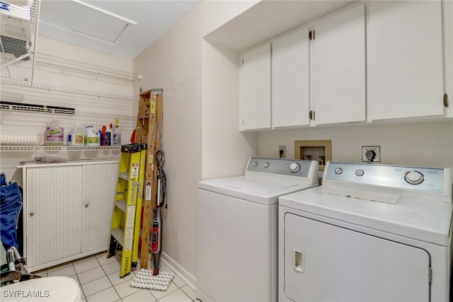 laundry room featuring cabinets, washing machine and dryer, and light tile patterned flooring