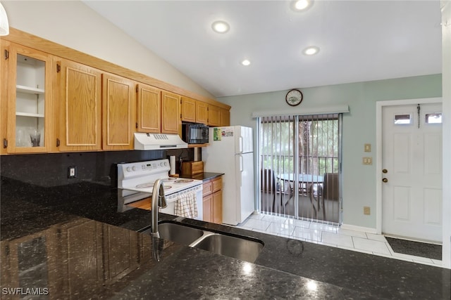 kitchen featuring lofted ceiling, sink, tasteful backsplash, white appliances, and dark stone countertops