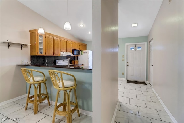 kitchen with white appliances, pendant lighting, a breakfast bar, kitchen peninsula, and lofted ceiling