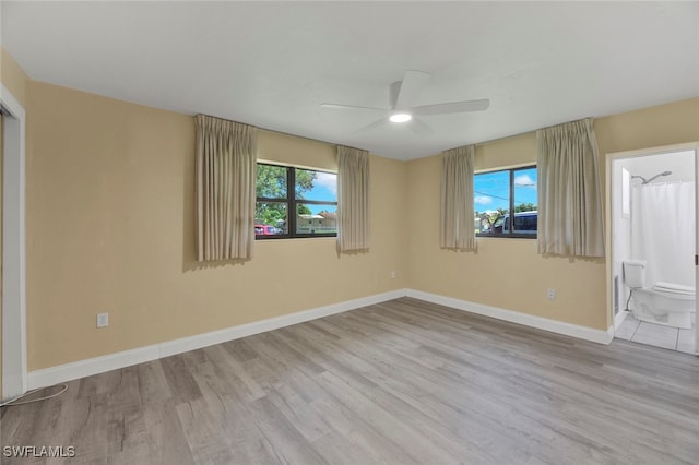 empty room featuring ceiling fan, a healthy amount of sunlight, and light hardwood / wood-style flooring